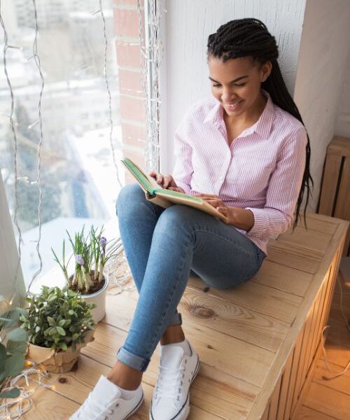 Jonge vrouw leest over Beleggen via Meesman en boeken over geld, financiën en money