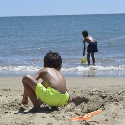 Jongens spelen op het strand
